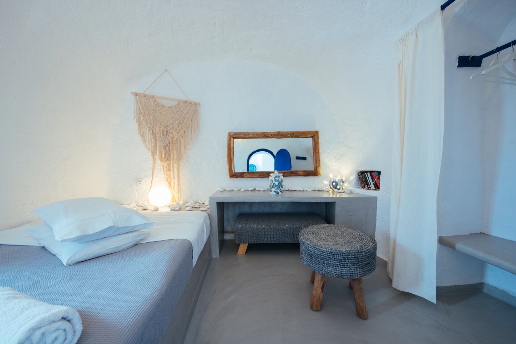 Een slaapkamer met een bed, nachtkastje en een zithoekje.