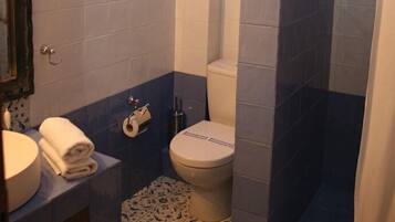 Une salle de bain avec des toilettes, un lavabo et une douche.