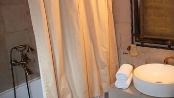 Une salle de bain avec une baignoire, un lavabo et une douche.