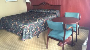 A hotel room with a bed, a round table, and two chairs. - Alcoa Inn (Alcoa)