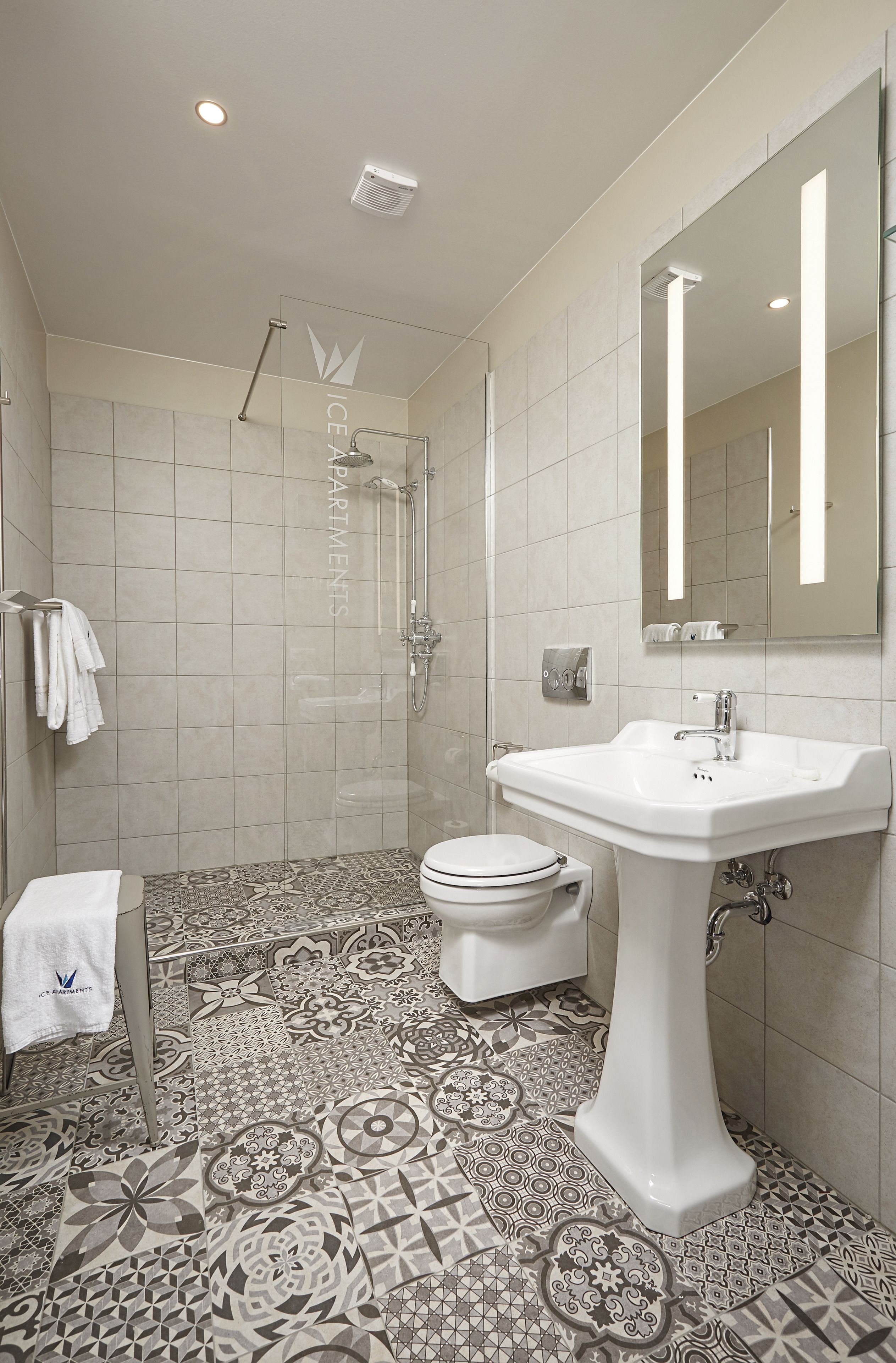Une salle de bain moderne équipée d’une douche, de toilettes et d’un lavabo.