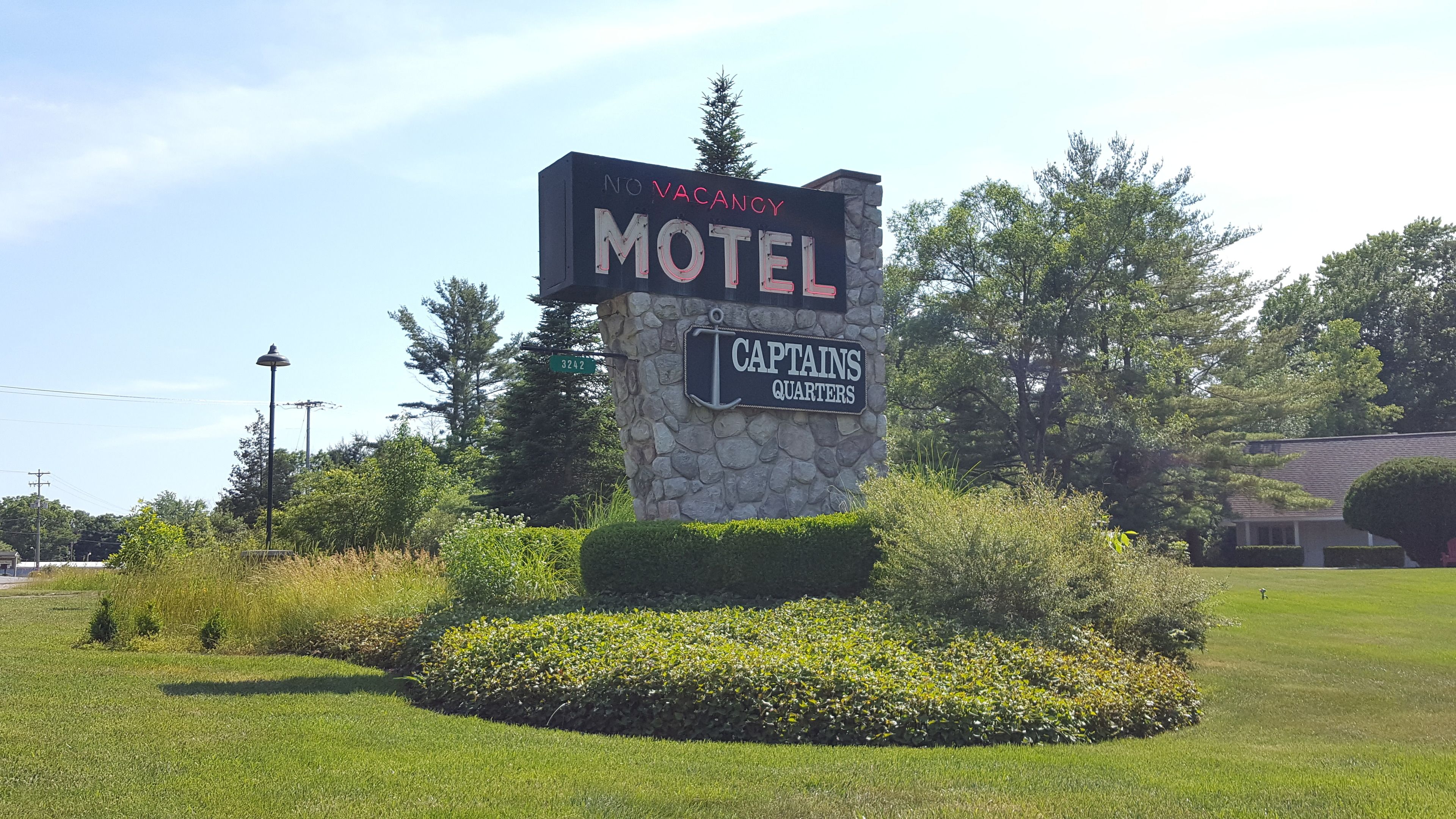 Señal de motel que indica 'NO VACANCY' y 'CAPTAINS QUARTERS', avisando que no hay habitaciones disponibles.