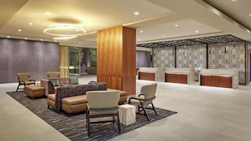 A modern lobby with seating, a reception desk, and a decorative wall.