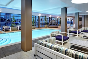 A poolside area with seating and a view of the cityscape.