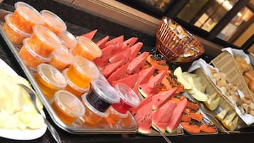 A buffet with various fruits and juices.