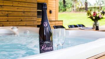 A bottle of wine and two glasses in a hot tub.