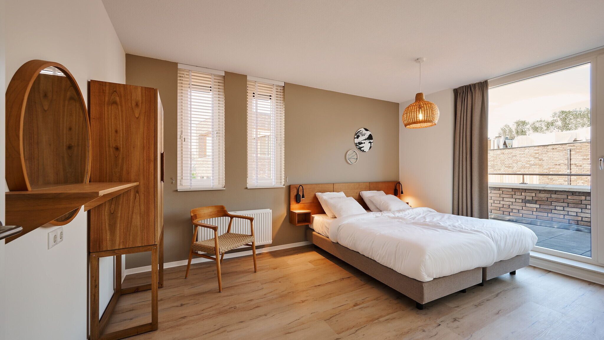 Ein Schlafzimmer mit einem Bett, einem Holztisch, einem Stuhl und einem Fenster mit Jalousien.