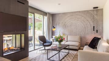 A modern living room with a fireplace, a sofa, a coffee table, and a decorative wall.