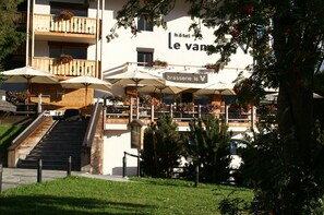 Et hotel med udendørs siddepladser, en trappe og et skilt med teksten "brasserie le V".