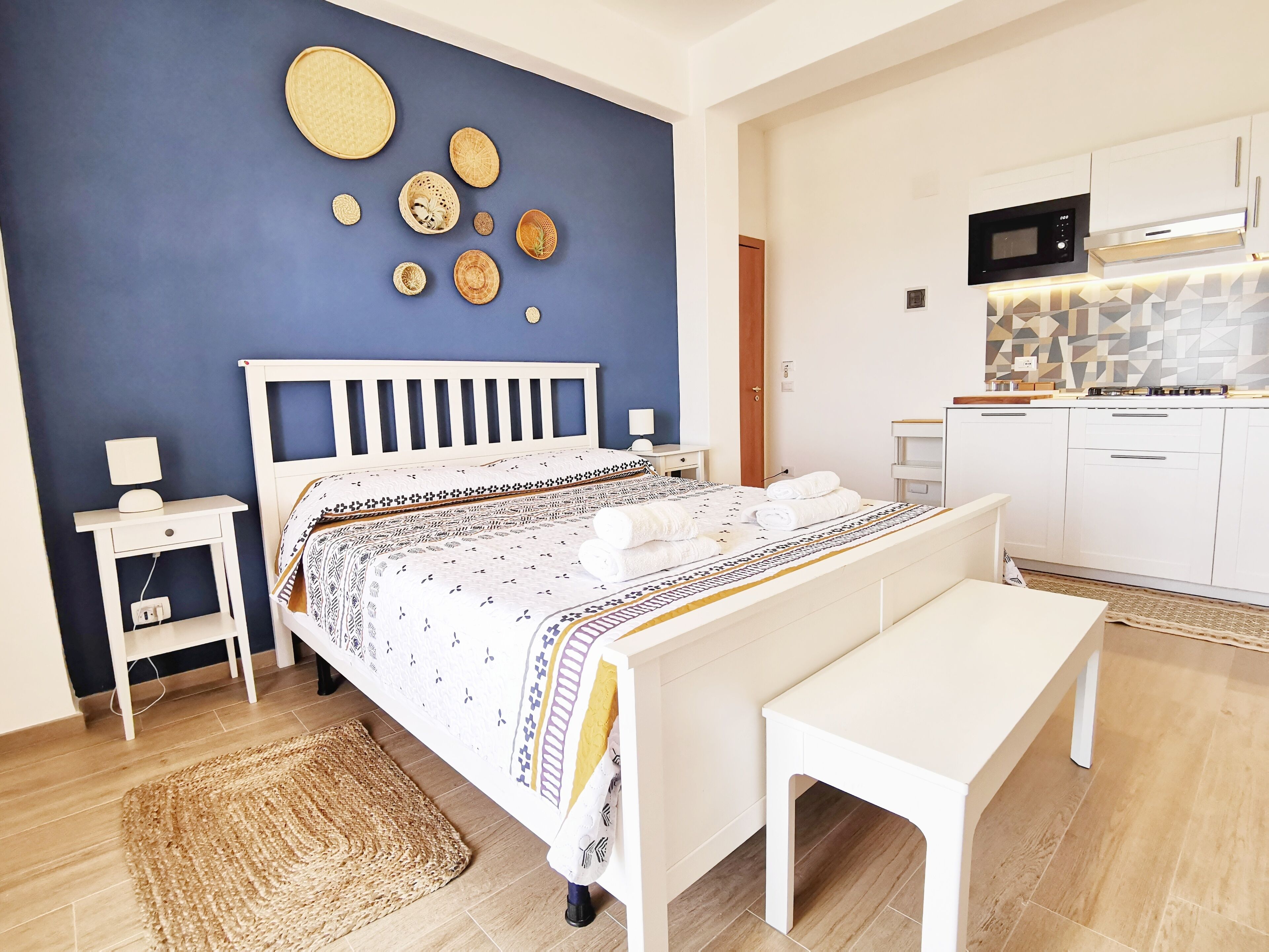 Una camera da letto con un letto, un comodino, una lampada e una parete decorata con piatti.
