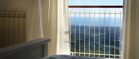 Un dormitorio con ventana a un paisaje montañoso.