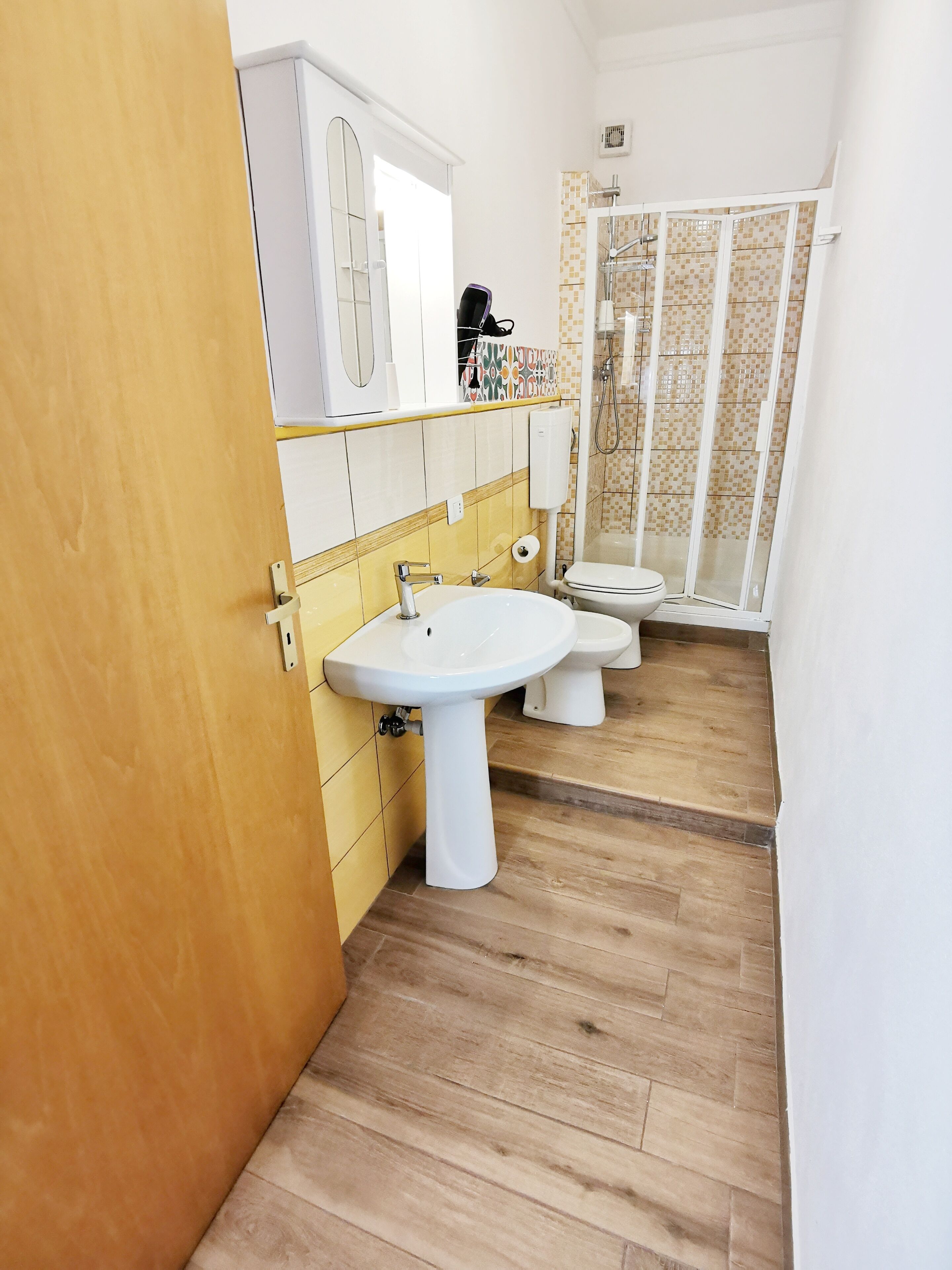 A bathroom with two sinks, a toilet, and a shower area.