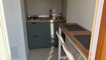 A compact kitchen with a stainless steel sink, a built-in stove, and a small countertop.