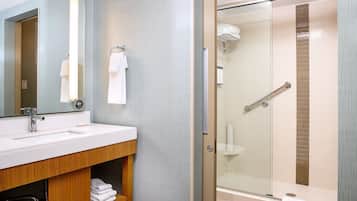 A modern bathroom with a vanity, a glass-enclosed shower, and a towel rack.