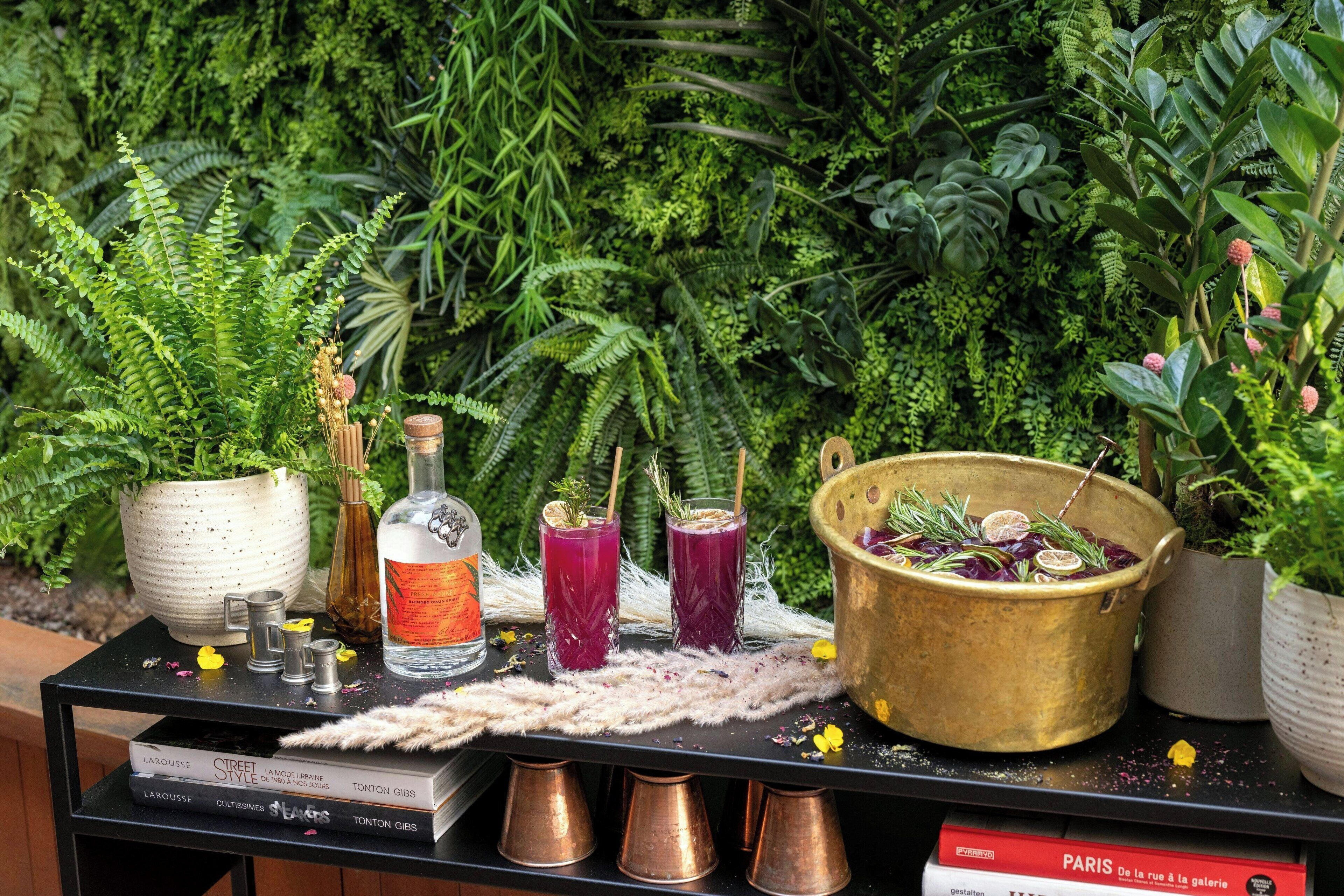 A table with drinks, a book titled "Paris," and a decorative bowl.