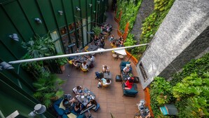 An indoor courtyard with seating areas, greenery, and a stone wall. - Renaissance Paris Republique Hotel (Paris)