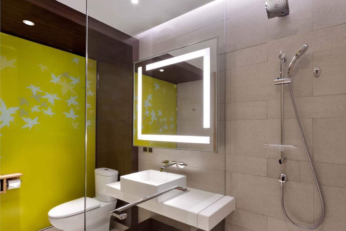 A modern bathroom with a toilet, sink, and shower.