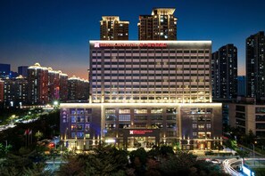 Un hotel Hilton Garden Inn de varios pisos con fachada moderna, ventanas amplias y señalización iluminada.