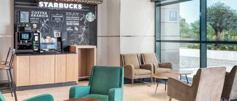 Ein Starbucks Kaffeehaus mit Sitzbereichen und einem großen Fenster.