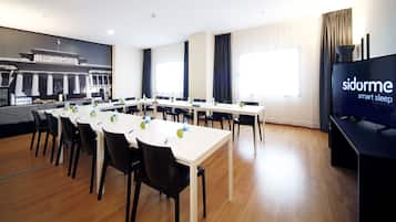 A conference room with a large table, chairs, and a television screen displaying 'sidorme smart sleep'.