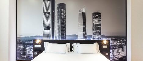Un dormitorio con una cama grande, un mural de un paisaje urbano en la pared y dos lámparas de noche.