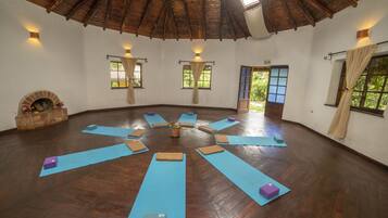 Une pièce spacieuse dotée d’un plancher en bois, aménagée avec des tapis bleus et de petits blocs pour les exercices.