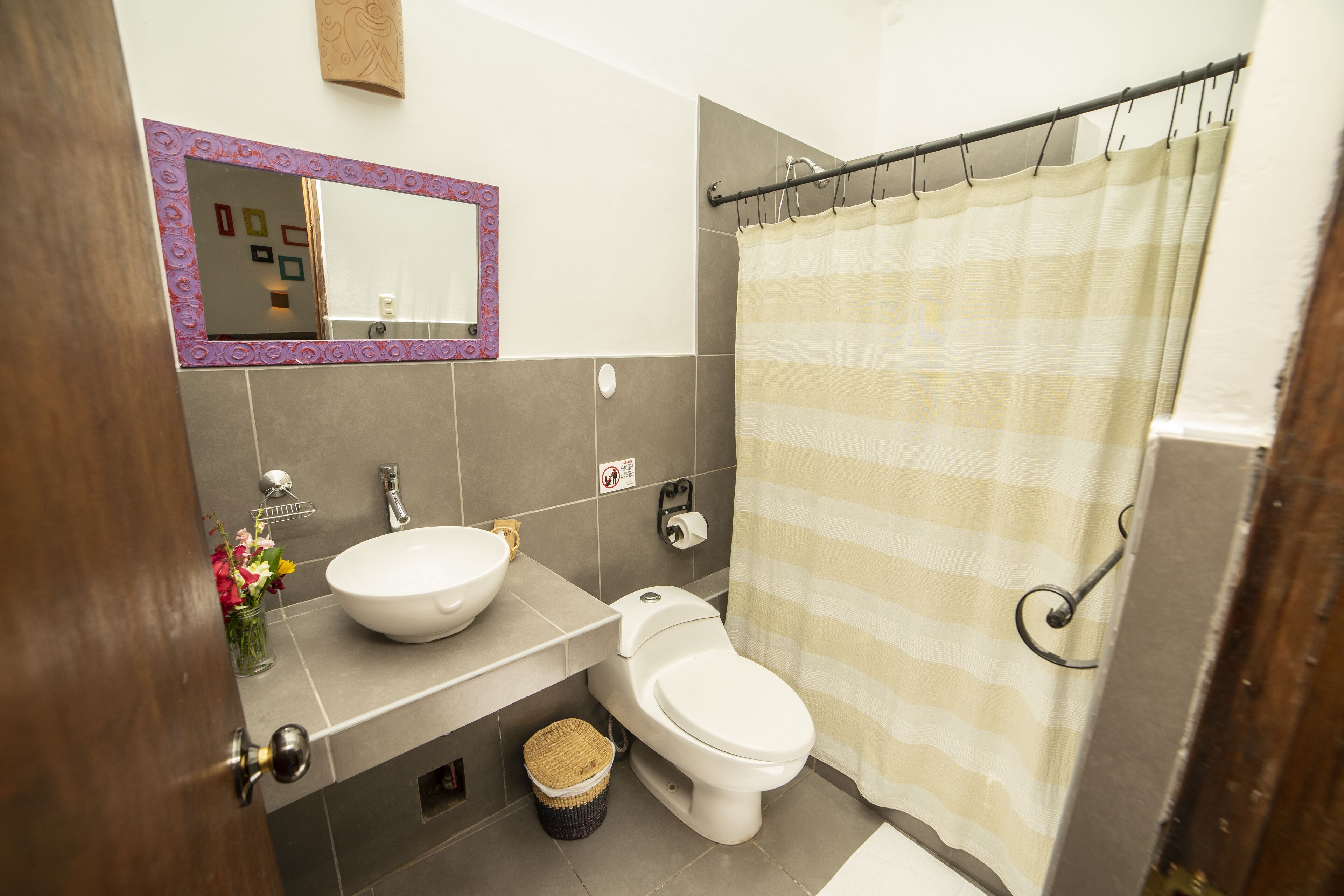 A bathroom with a white sink, a toilet, and a shower curtain.
