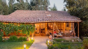 A house with a tiled roof, a covered porch, and a garden pathway. - Andean Wings Valley (Urubamba)