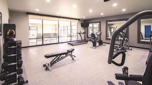 A gym with treadmills, dumbbells, and exercise equipment.