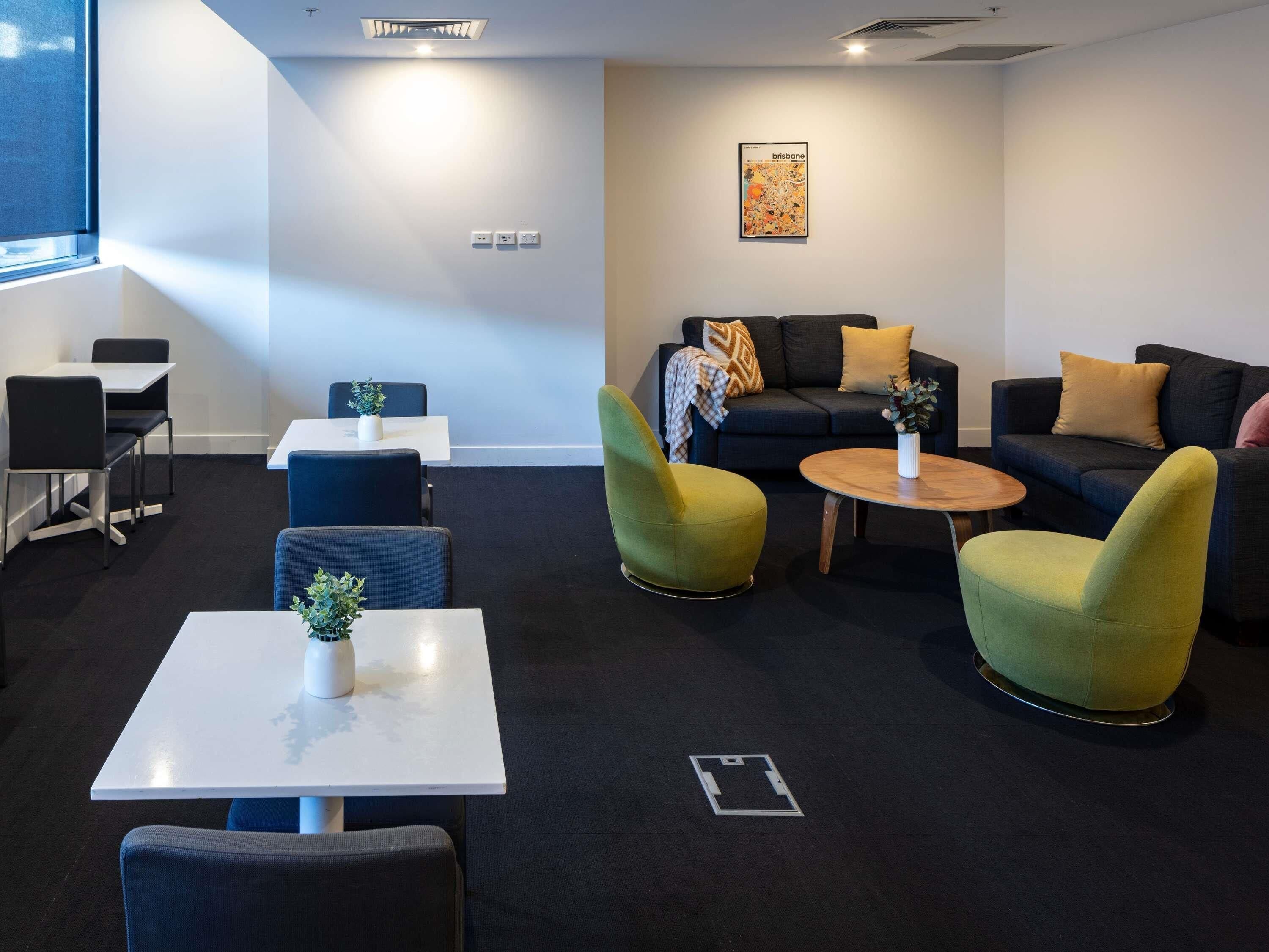 Ein stilvoller Lounge-Bereich mit einer Couch, Sesseln, einem Couchtisch und einem kleinen Tisch mit einer Pflanze.