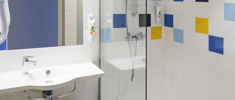 A modern bathroom with a glass shower enclosure, a white sink, and a mirror.