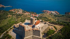 An aerial view of a historic fort with a central tower, surrounded by lush greenery and coastal views. - ibis Styles Collioure Port Vendres (Port-Vendres)