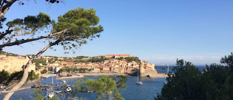 Un pueblo costero con un fuerte histórico, un puerto deportivo y una vista despejada del mar.