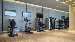 A modern gym with various exercise equipment, including treadmills and weight machines, and a large mirror wall. - Novotel Suzhou SIP (Suzhou)