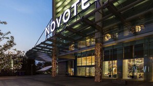 A hotel entrance with a modern design, featuring a prominent 'NOVOTEL' sign and a covered entrance area. - Novotel Suzhou SIP (Suzhou)
