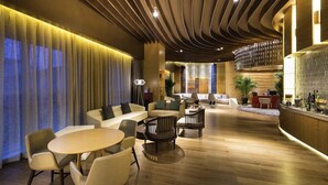 A modern hotel lobby with a central seating area, a bar, and a reception desk. - Novotel Suzhou SIP (Suzhou)
