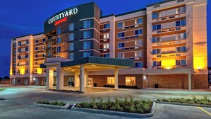 Een Courtyard Marriott hotel met meerdere verdiepingen, een overdekte ingang en een parkeerplaats.