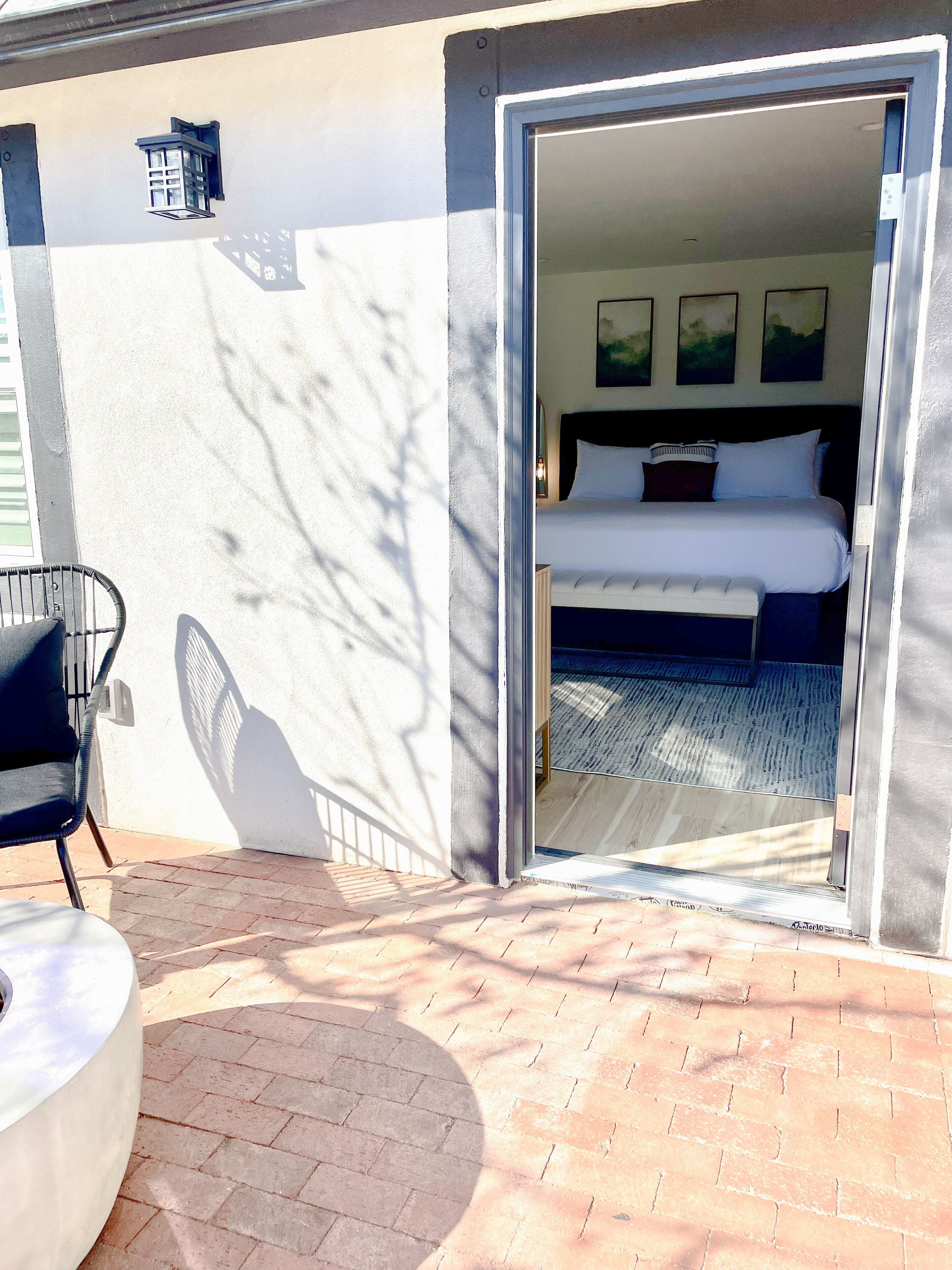 A hotel room with a bed, a chair, and a small table.