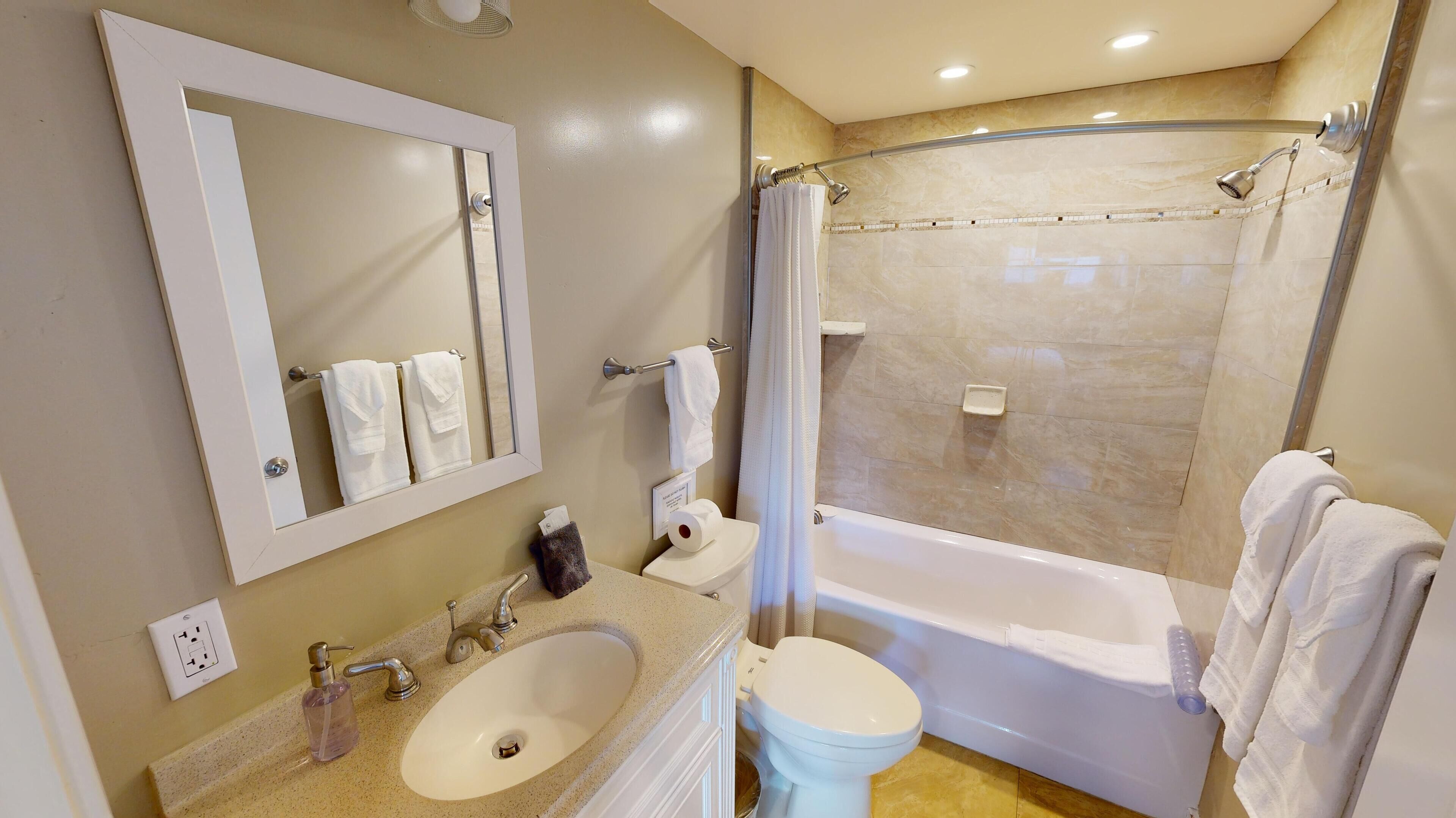 Een badkamer met een wastafel, toilet en bad.