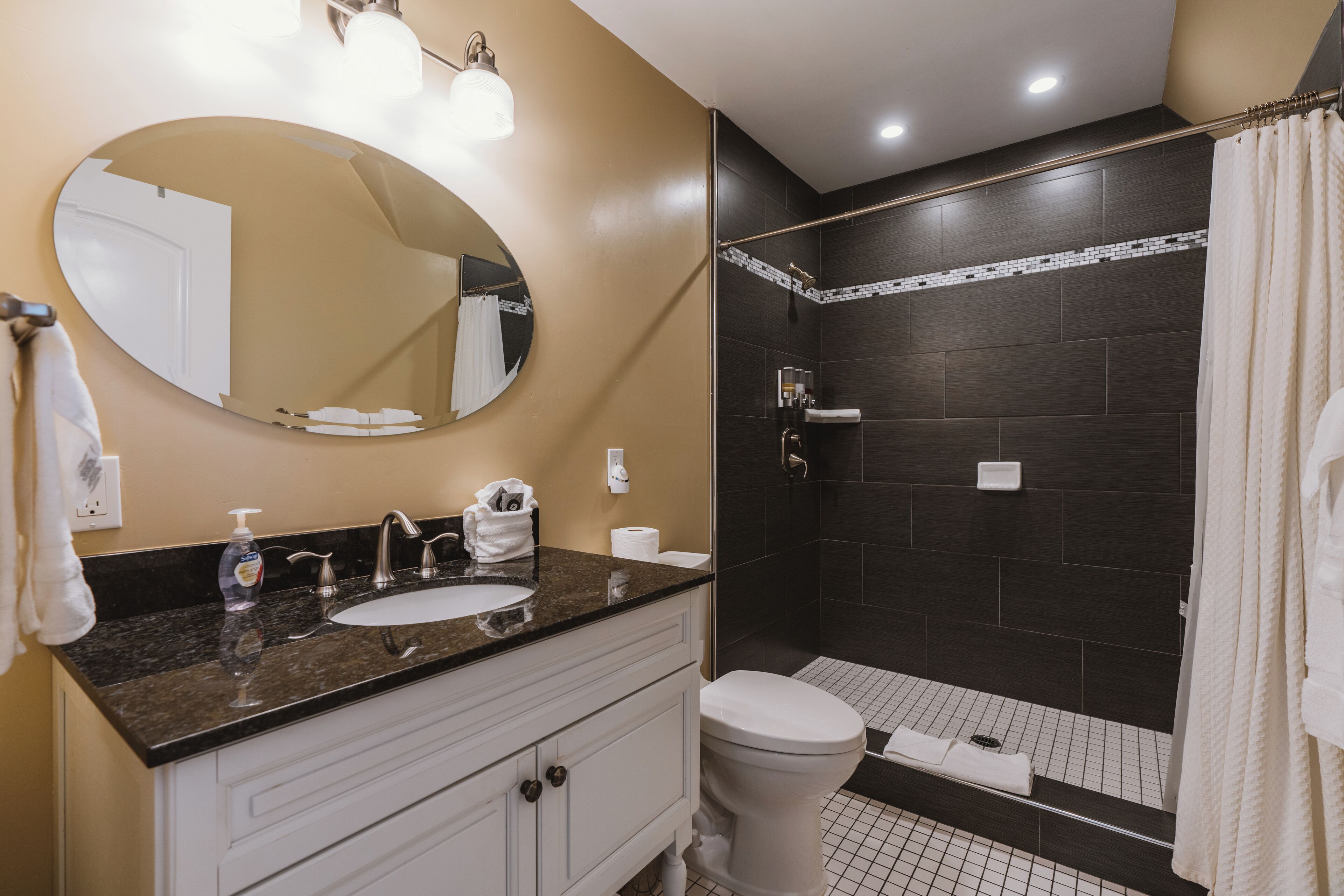 Een badkamer met een wastafel, spiegel en toilet.