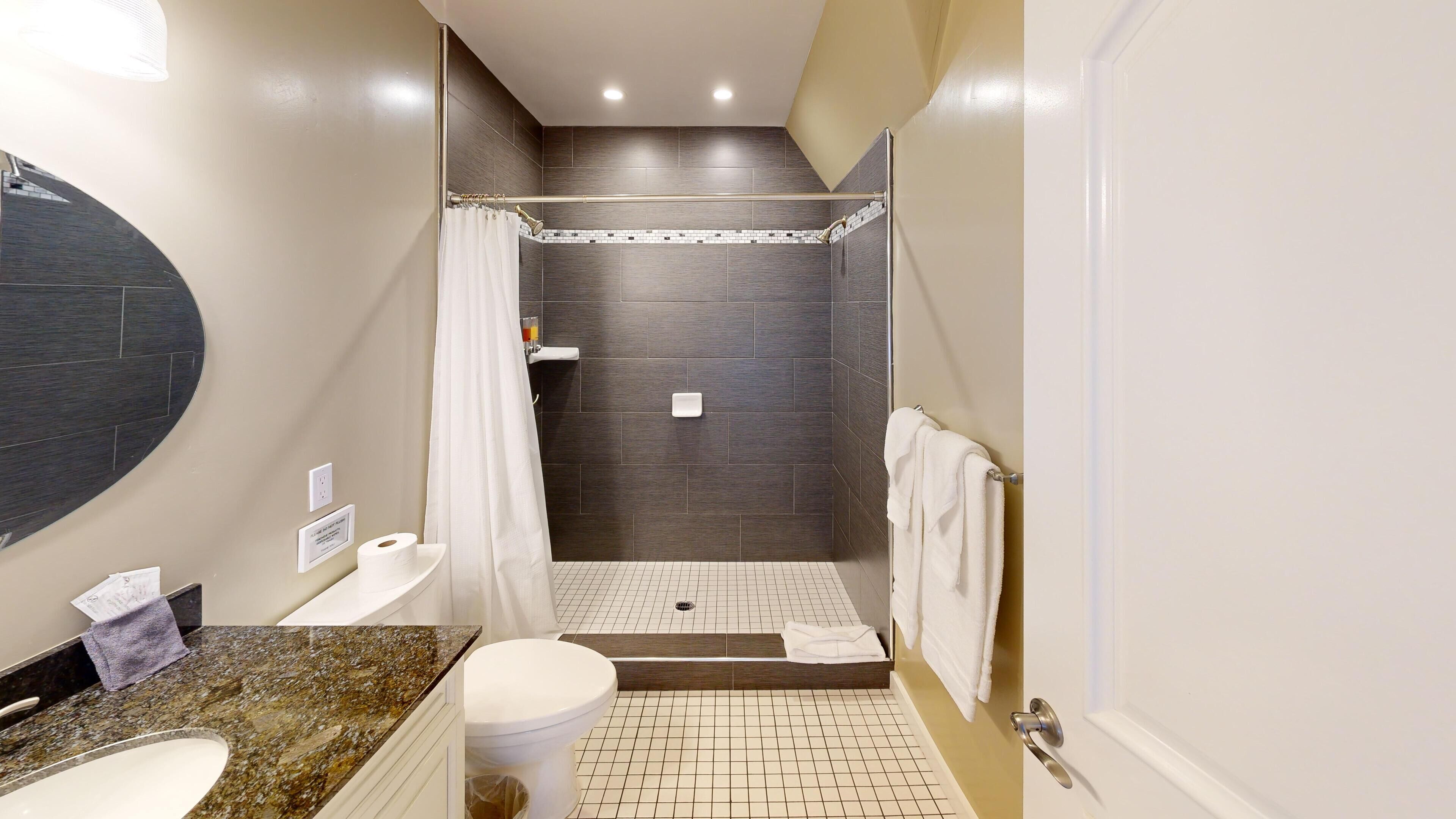Un baño moderno con ducha, inodoro y lavamanos.