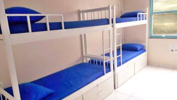 A bunk bed room with white railings and blue bedding.