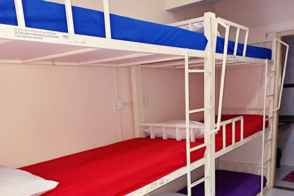 A bunk bed room with three levels, each with a mattress.
