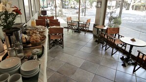A restaurant with outdoor seating, a variety of food items, and a view of the street. - Xumec Apart Hotel (Mendoza)
