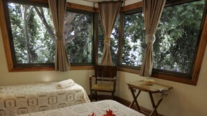 A hotel room with a large bed, a small table with breakfast items, and a window with curtains. - Xumec Apart Hotel (Mendoza)