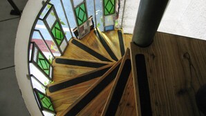 A spiral staircase with wooden steps and glass railings. - Xumec Apart Hotel (Mendoza)