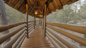 A wooden boardwalk with railings, surrounded by trees. - Bear Creek Motel And Cabins (Silver City)
