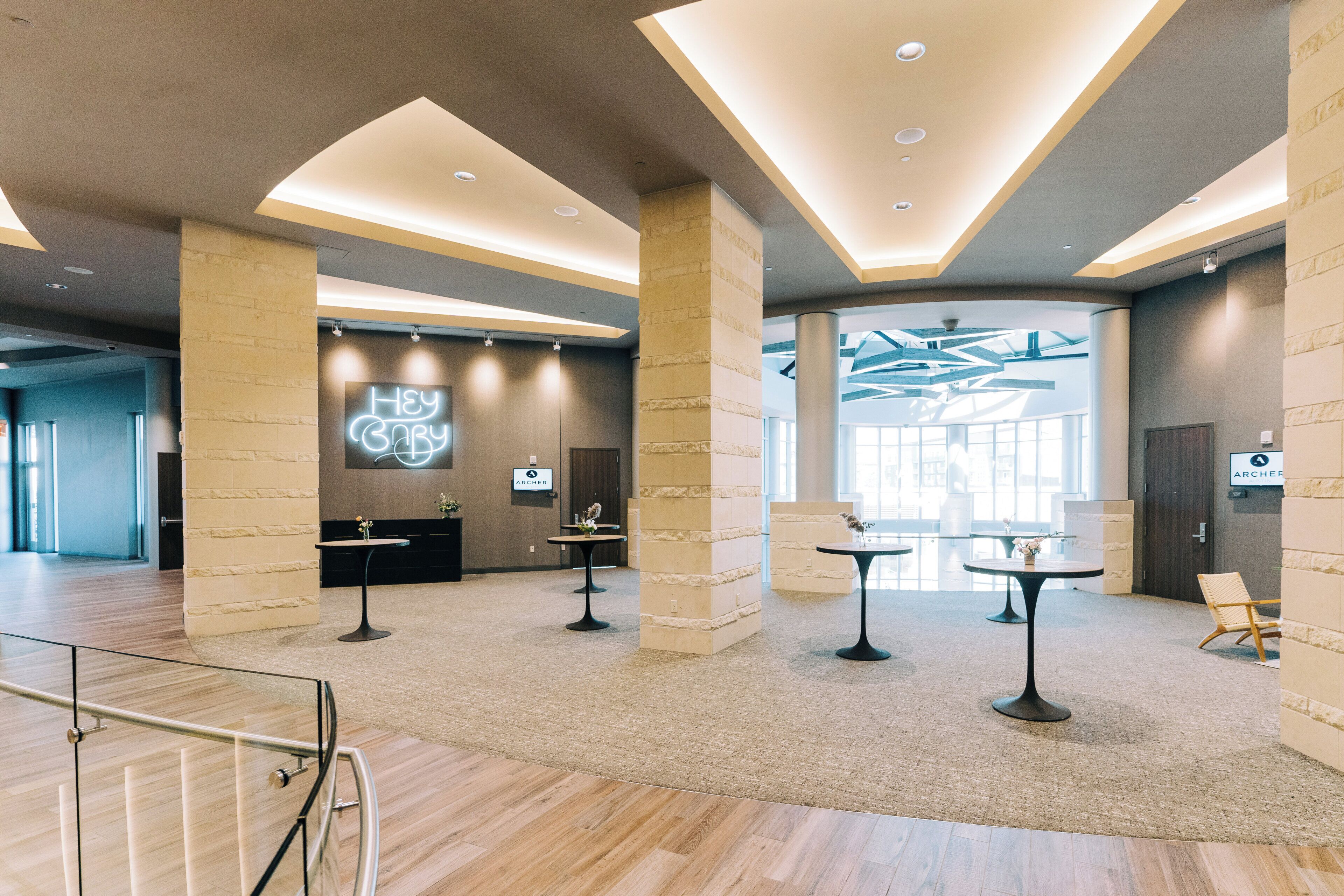 Un hall d’entrée spacieux, doté d’un plafond haut, d’un éclairage moderne et d’un comptoir de réception central.