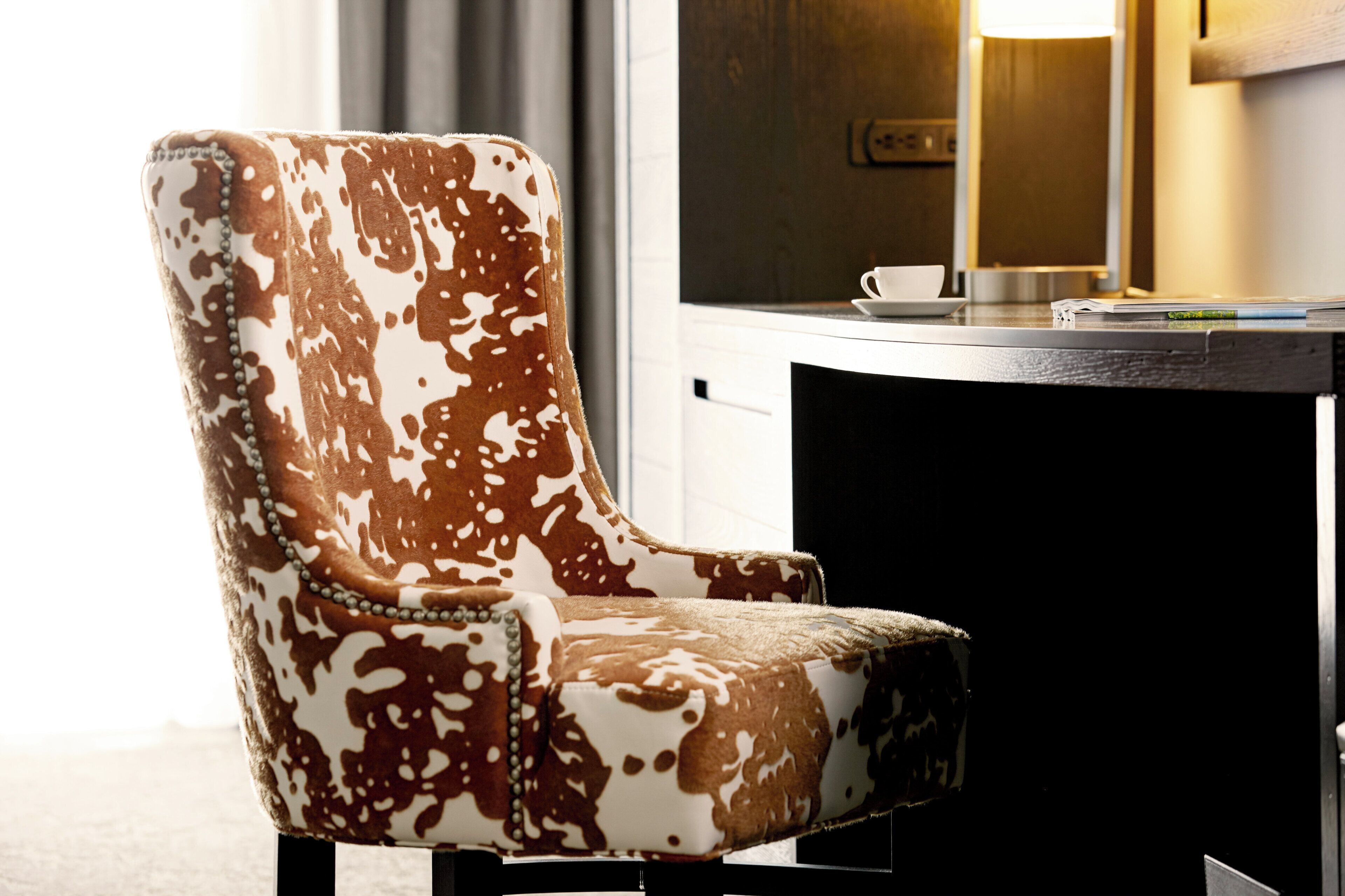 A chair with a cowhide pattern upholstery.