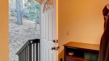 A wooden door with a small window, a wooden bench, and a shelf with a plate and a sign.